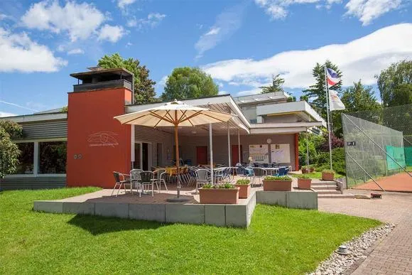 Clubhaus des TC Zollikon mit Terrasse und Sonnenschirm