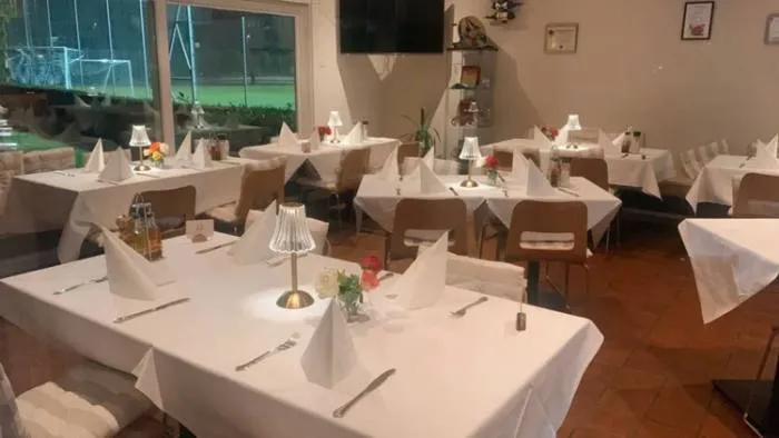 Gedeckte Tische im Restaurant mit Blick auf die Tennisplätze